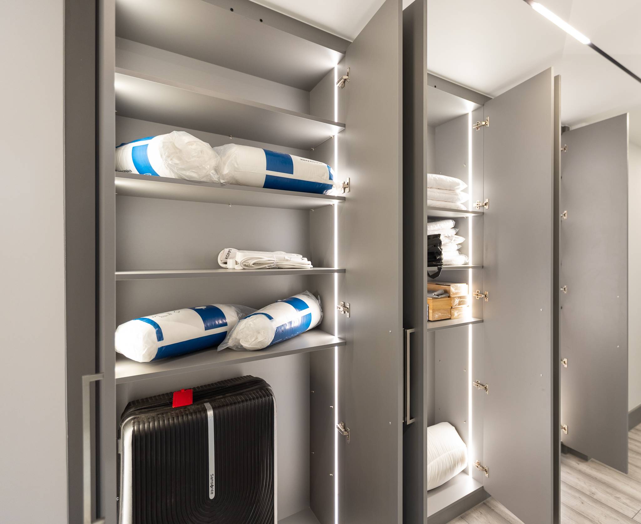 Lit storage cupboard with adjustable shelves for linen and luggage