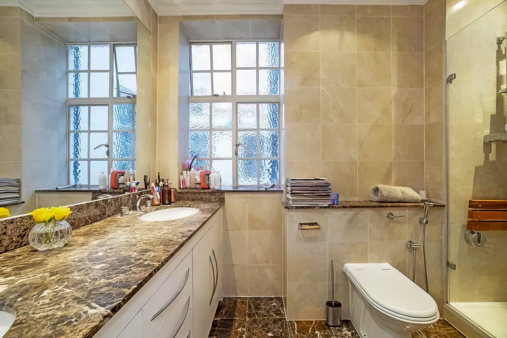 One of the original bathrooms, with brown marble worktops and beige tiles