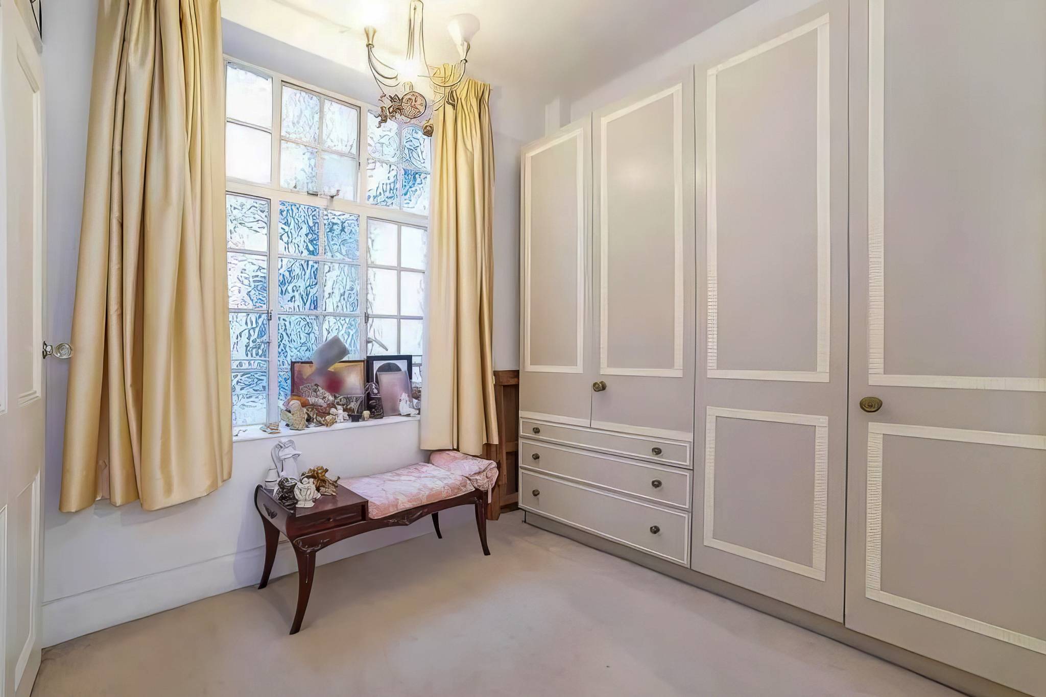 Bedroom before, with old painted built in wardrobes beside the window
