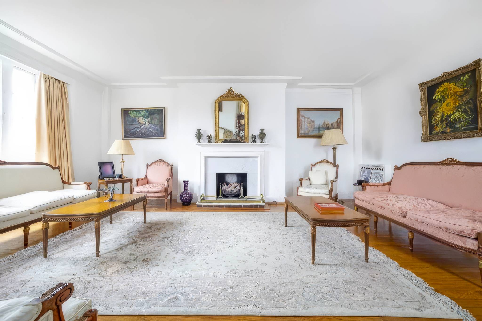 Living room before, with pink sofas, an old fireplace and a wooden floor