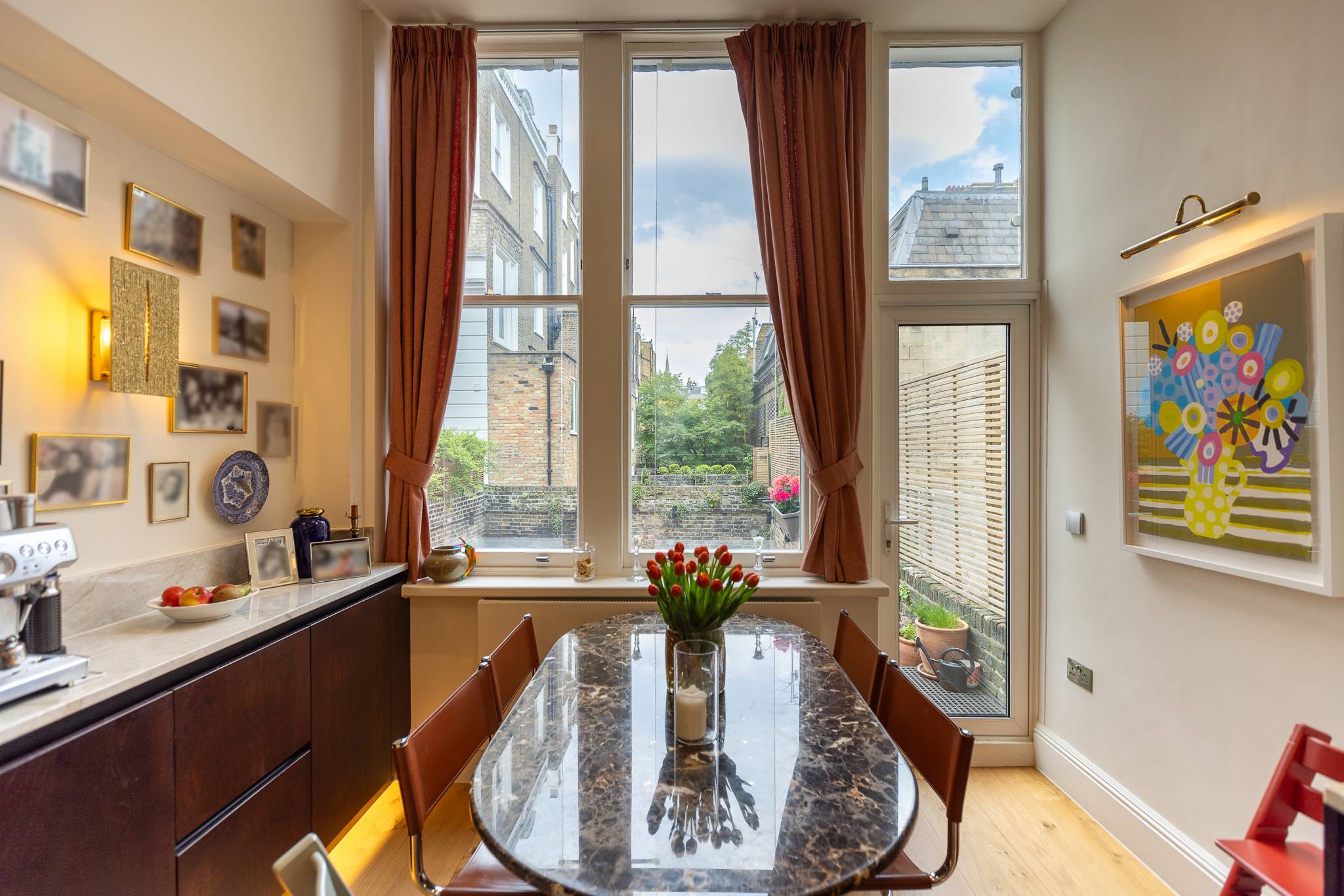 Kitchen and dining area at Phillimore Gardens with tall windows onto the garden