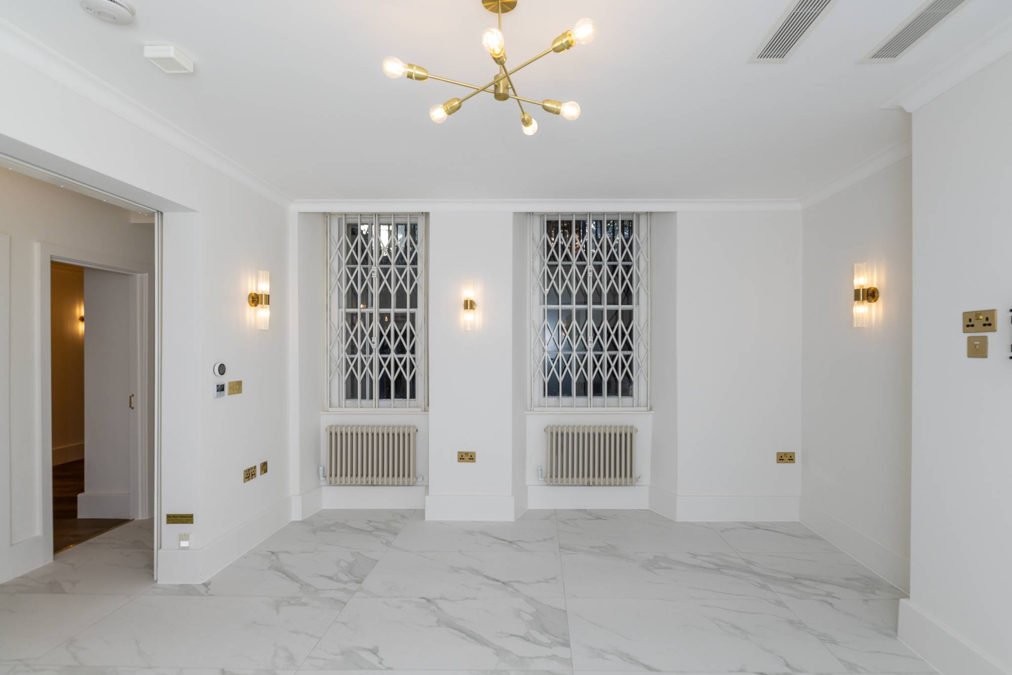 Room at Queen's Gate with a marble floor, brass wall lights and sash windows