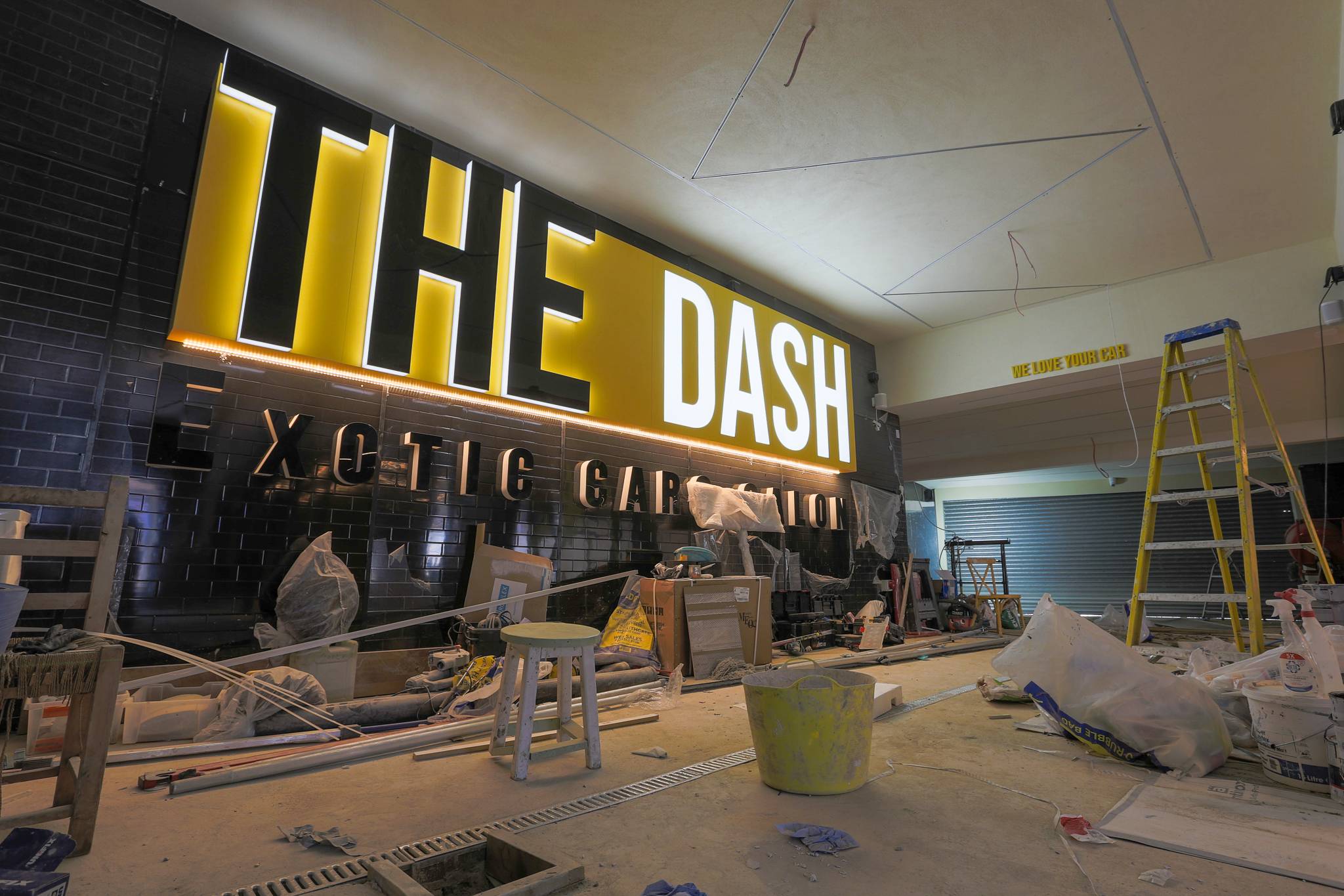 The Dash car wash in Park Royal with its illuminated sign on a black clad wall